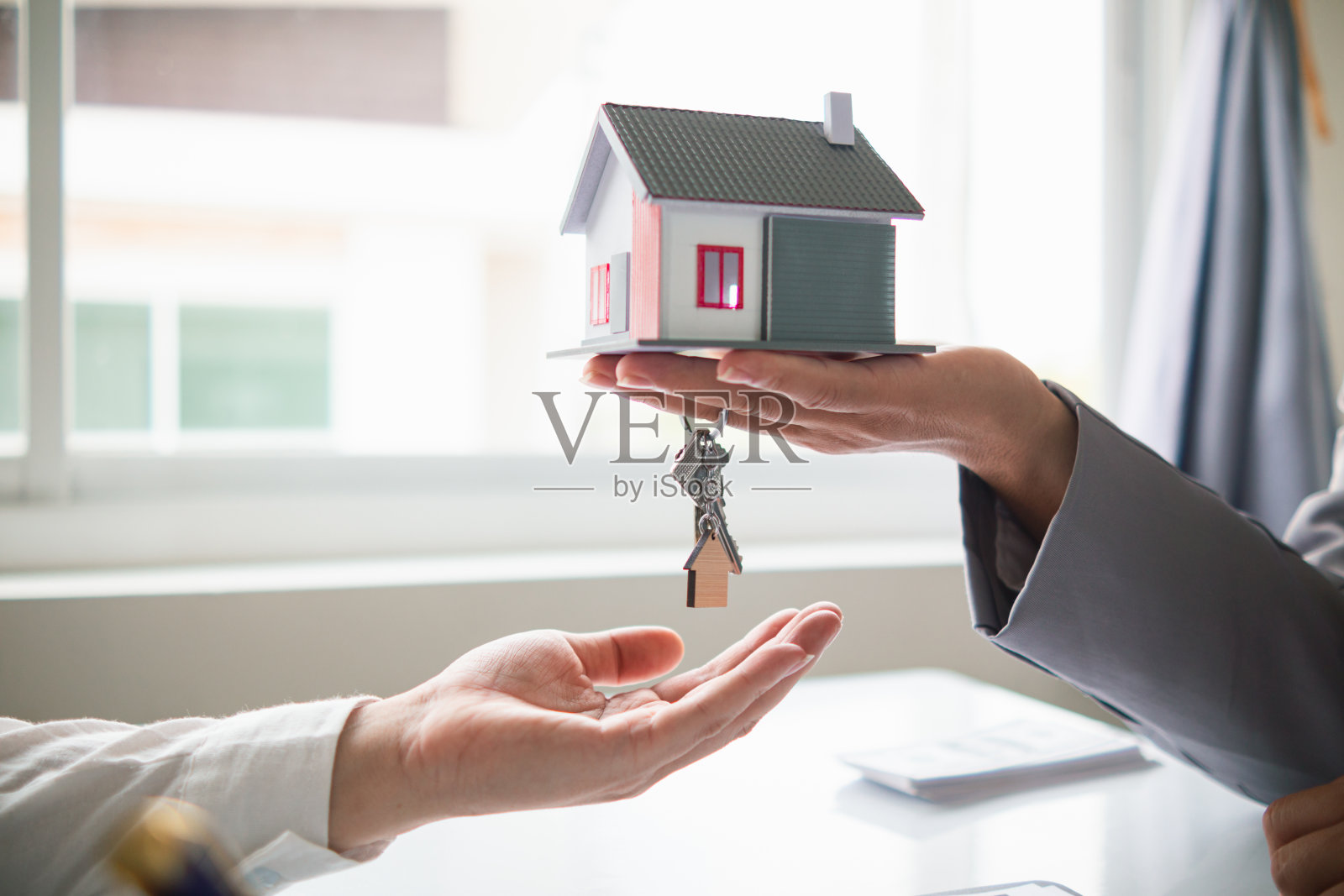 房地产经纪人提供样房供客户选择，并推荐房地产保险促销活动来保护他们的财产。提供房地产和房屋保险的概念照片摄影图片