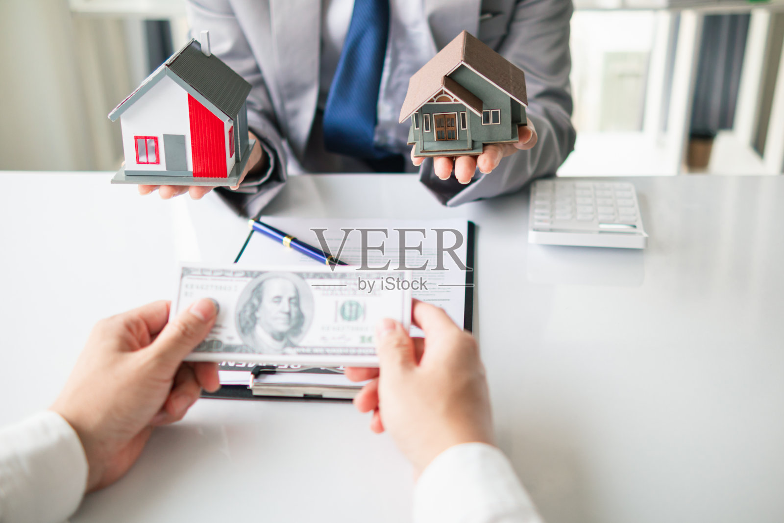 房地产经纪人提供样房供客户选择，并推荐房地产保险促销活动来保护他们的财产。提供房地产和房屋保险的概念照片摄影图片