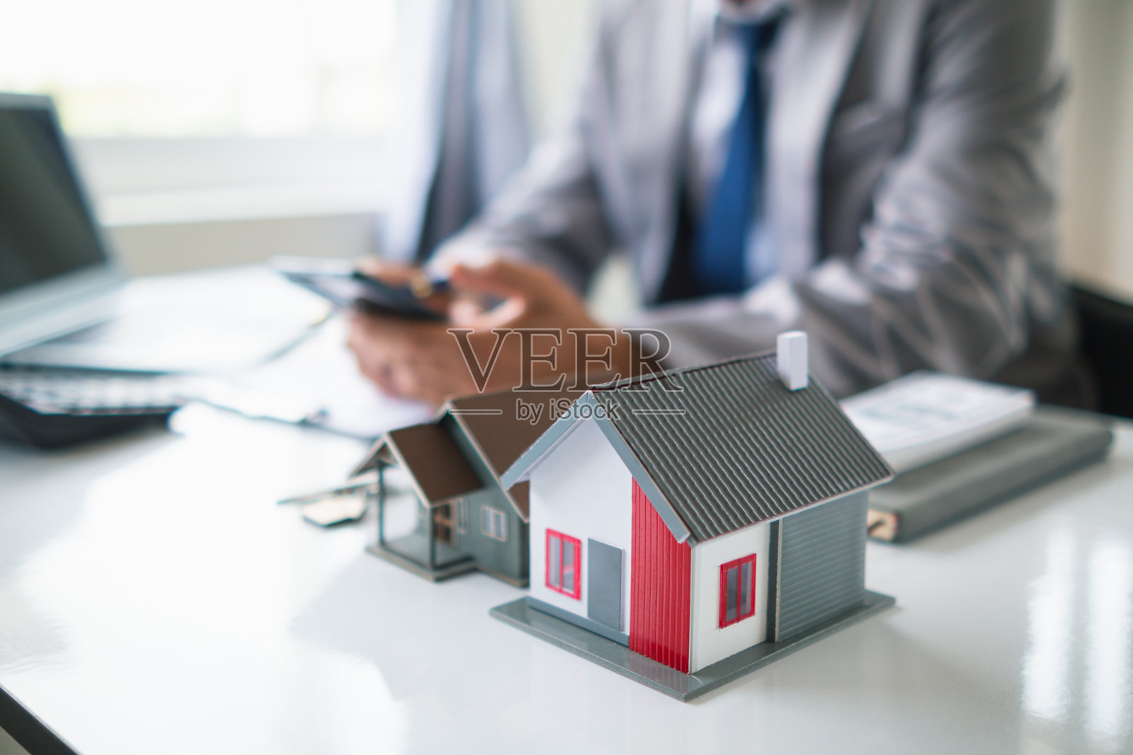 房地产经纪人提供样房供客户选择，并推荐房地产保险促销活动来保护他们的财产。提供房地产和房屋保险的概念照片摄影图片