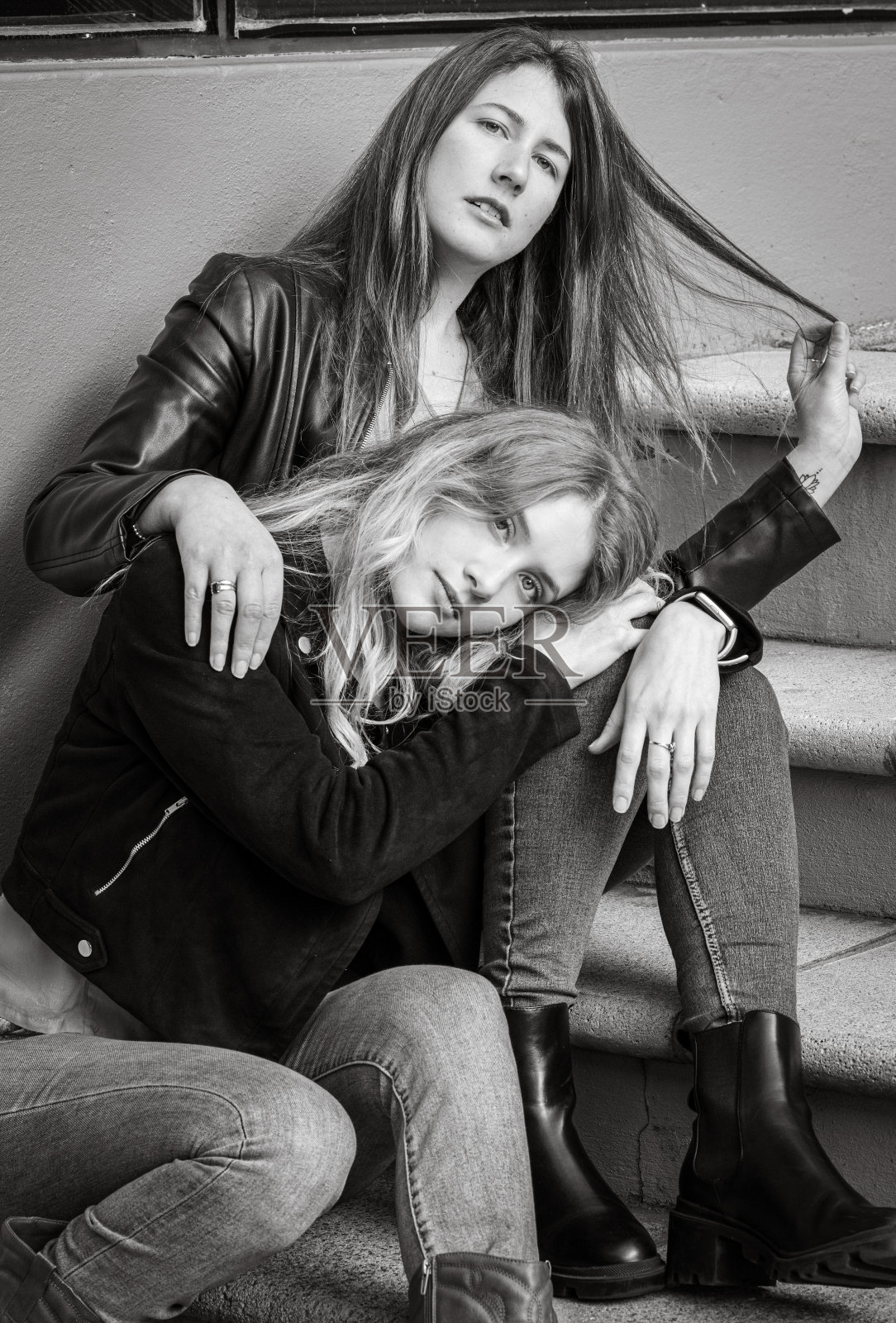 两个女性朋友在城市环境中坐在楼梯上的灰度照片照片摄影图片