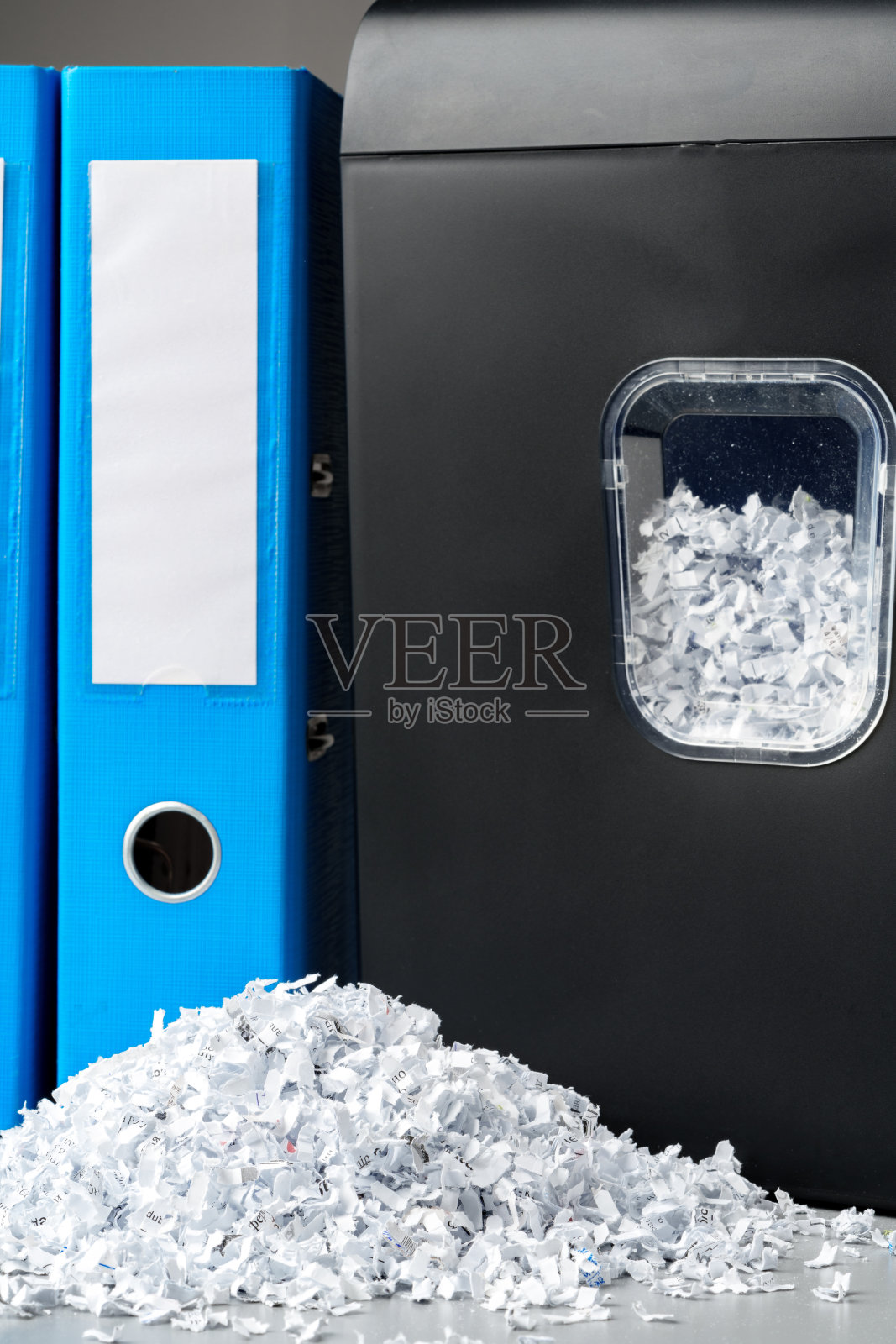 办公桌上的办公室碎纸机，背景是灰色的照片摄影图片