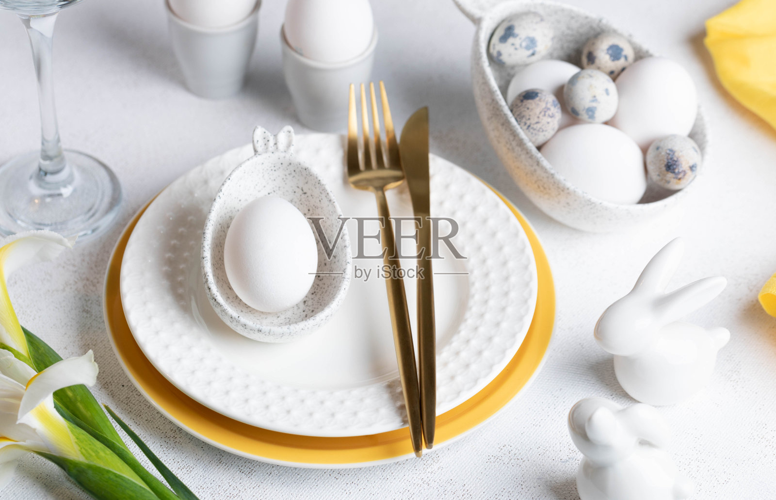 节日优雅的白色与黄色复活节餐桌设置近距离。照片摄影图片