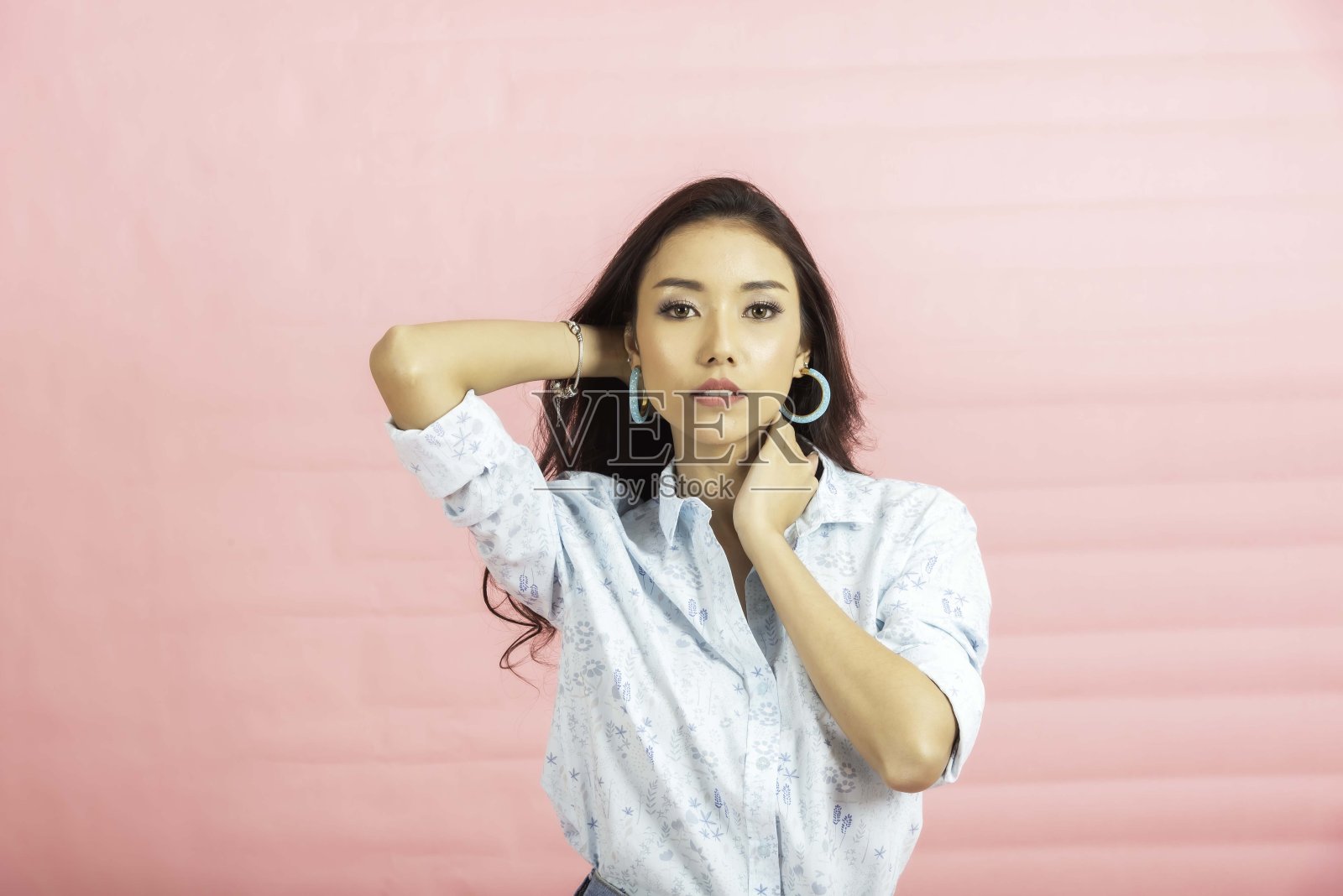 快乐的年轻女子视图采取工作室粉红色的背景。照片摄影图片