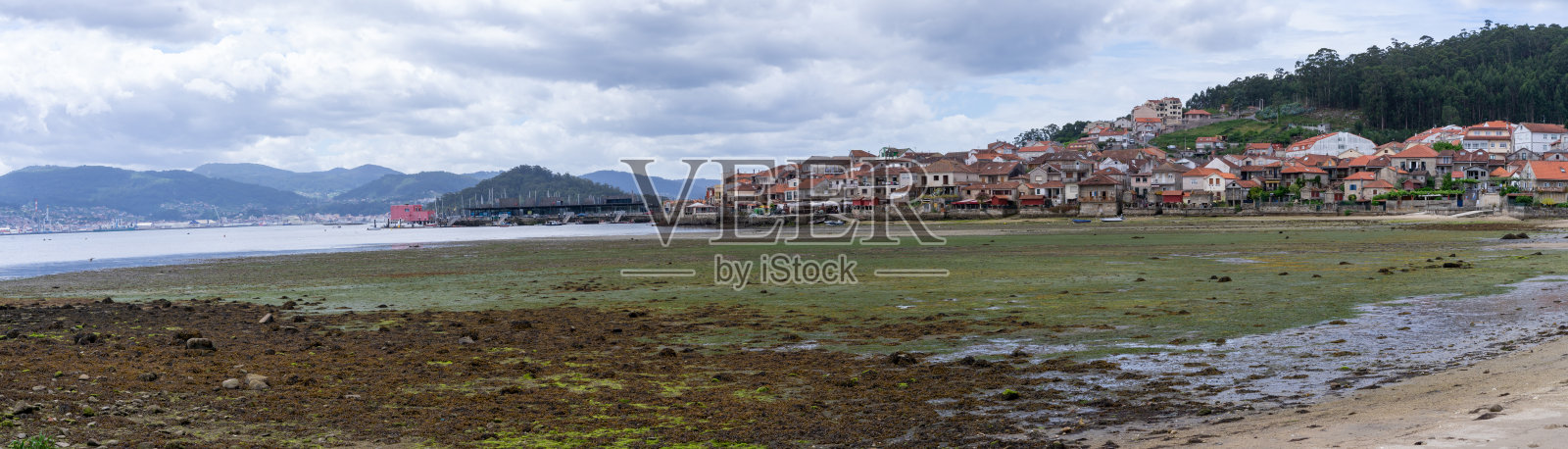 Combarro Pontevedra。以小镇为背景的海滩照片摄影图片
