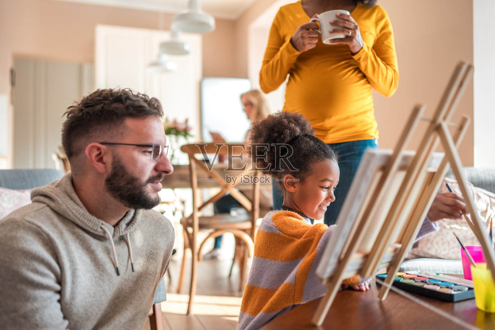 白人父亲在家看混血儿女儿画画照片摄影图片