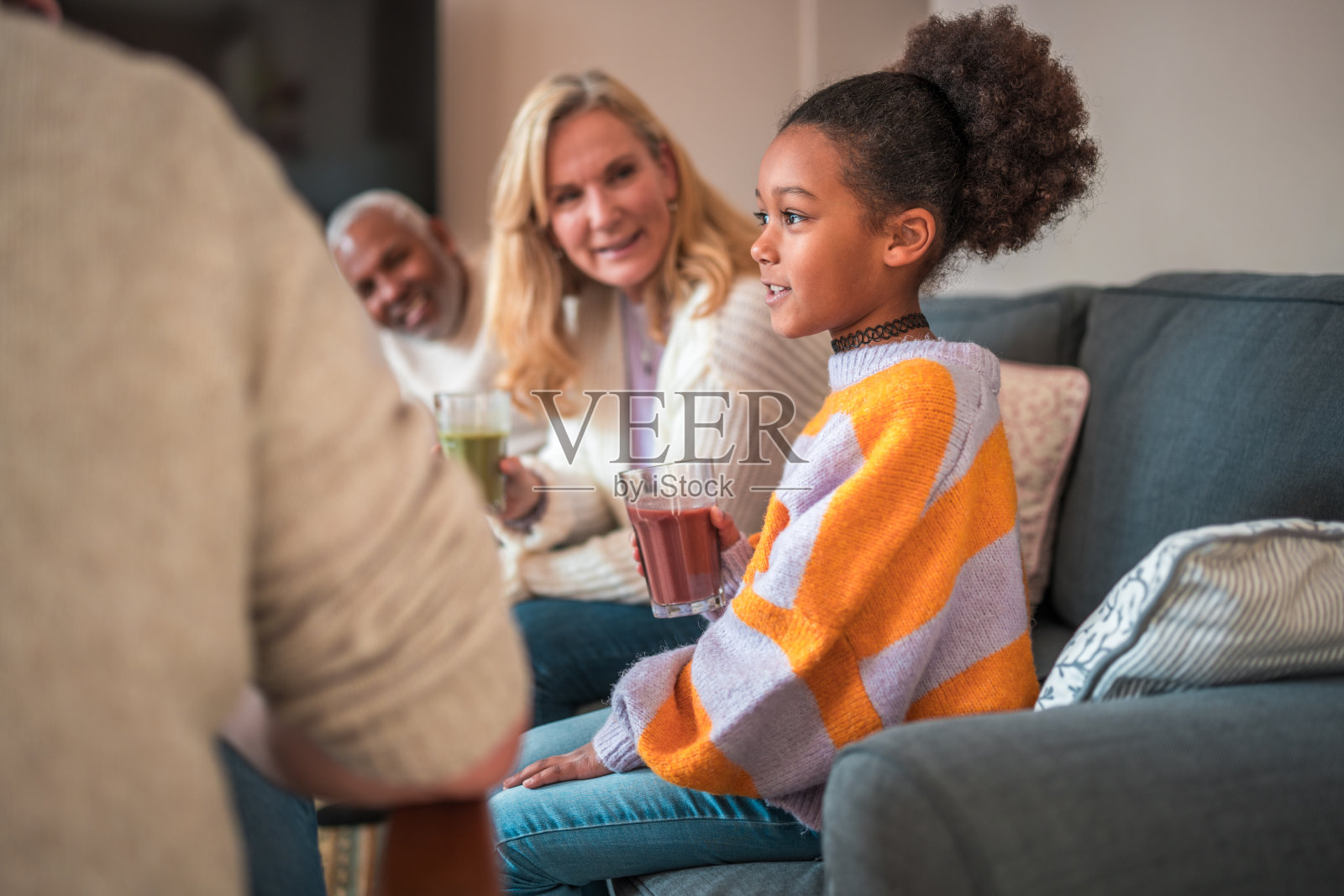 不同的家庭享受饮料在舒适的客厅照片摄影图片