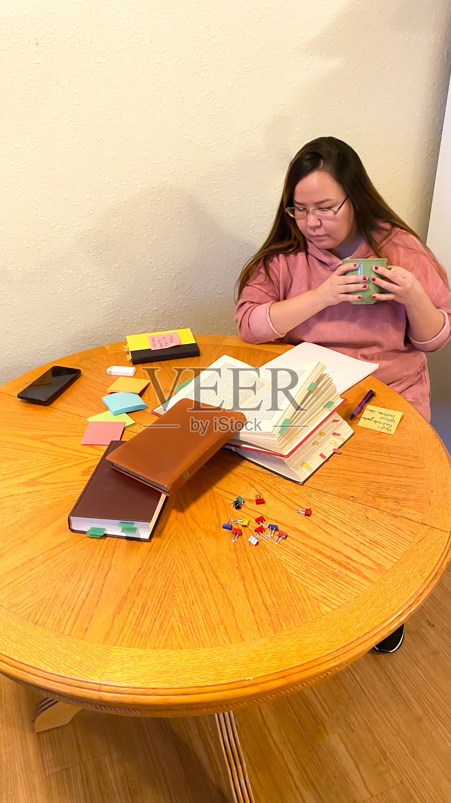 一名妇女使用不干胶笔记帮助完成在线课程照片摄影图片