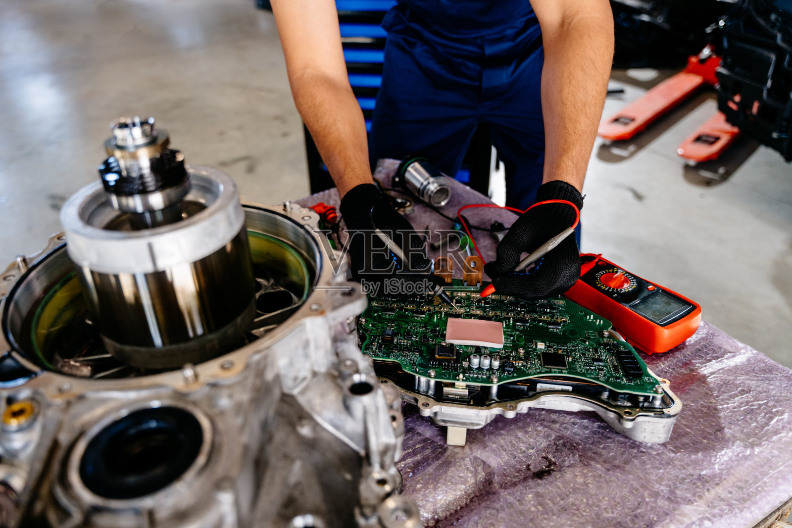 变速箱从汽车上拆下来修理的电动汽车发动机阿拉伯人工作内部永磁同步磁阻电动机。工业到发动机维修的服务维护。照片摄影图片