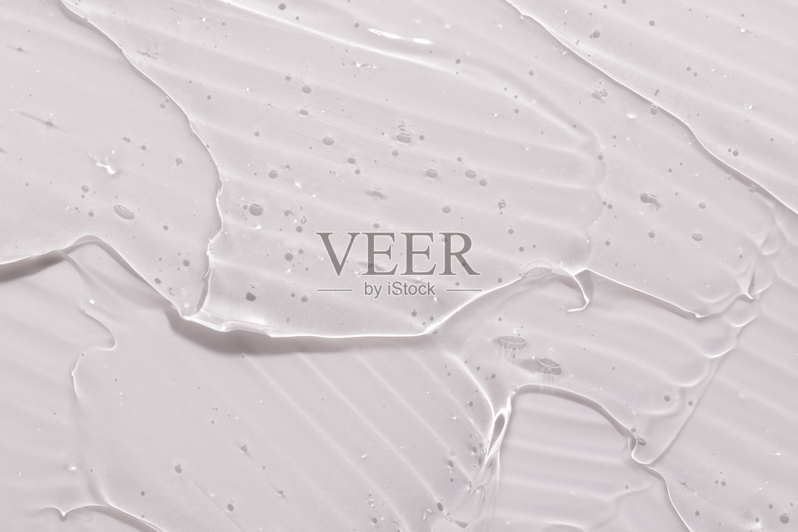 透明液体凝胶在粉红色的背景。化妆品护肤品的质地。面霜，身体乳照片摄影图片