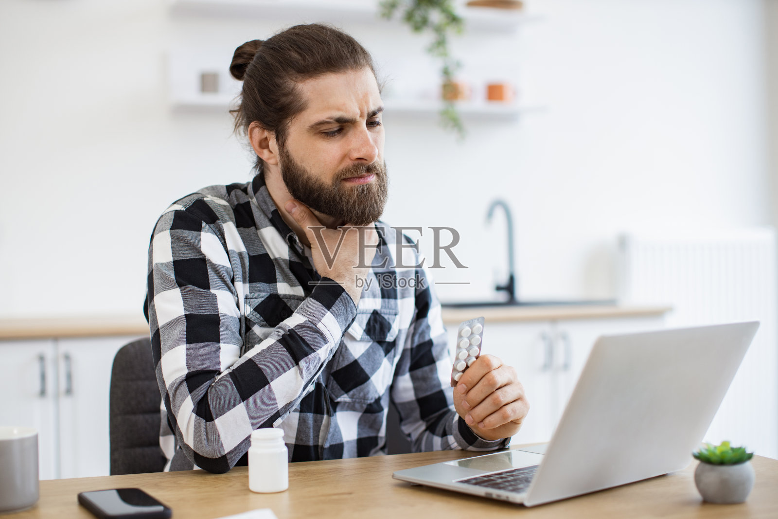 穿着便服的生病的年轻人摸着疼痛的喉咙。照片摄影图片