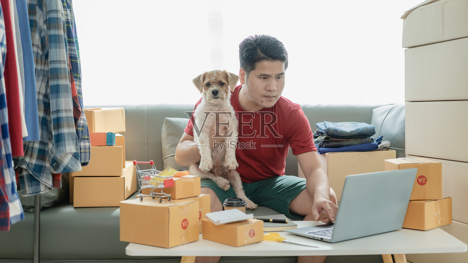 网店老板在网上检查网站上的订单，与客户确认订单，并将产品包装在包裹箱中发货。中小企业概念网上销售产品照片摄影图片