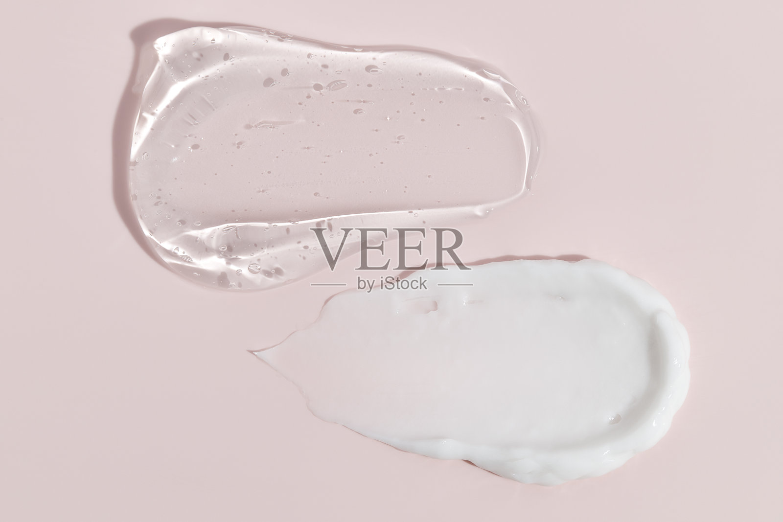 粉嫩的粉红色背景上的奶油质感的化妆品涂抹。面霜，身体乳照片摄影图片