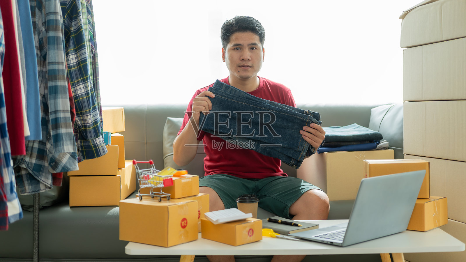 网店老板在网上检查网站上的订单，与客户确认订单，并将产品包装在包裹箱中发货。中小企业概念网上销售产品照片摄影图片