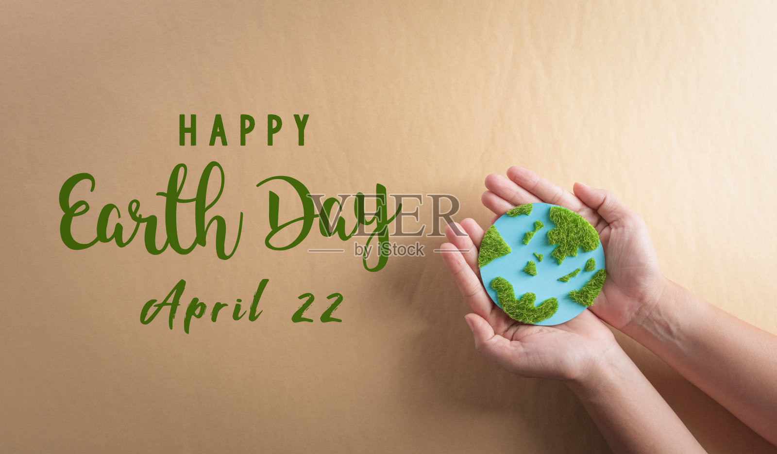 手里拿着棕色背景上有草的纸土。世界环境日，地球日和拯救地球的理念。照片摄影图片