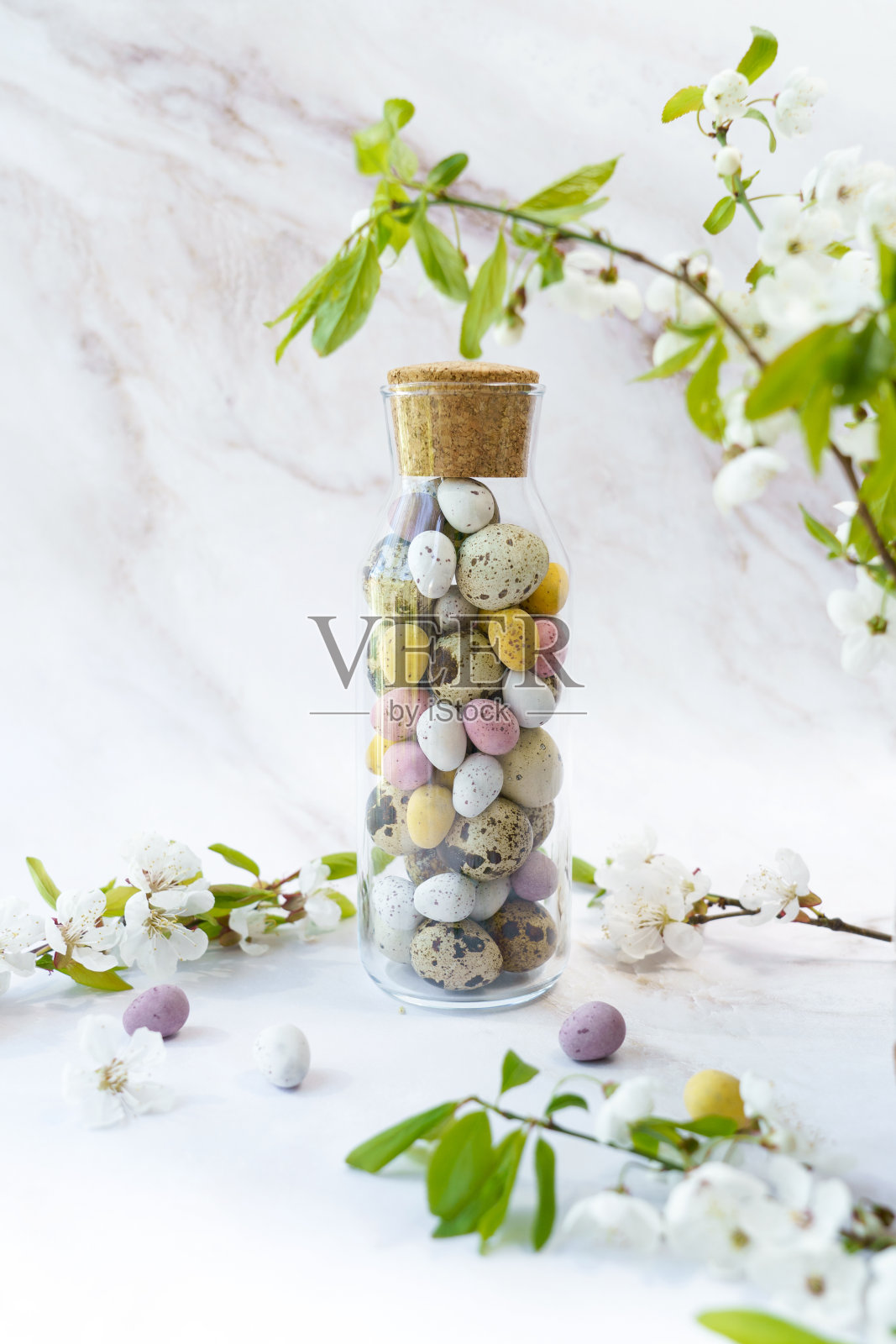 一个装满复活节彩蛋和鲜花的玻璃瓶照片摄影图片