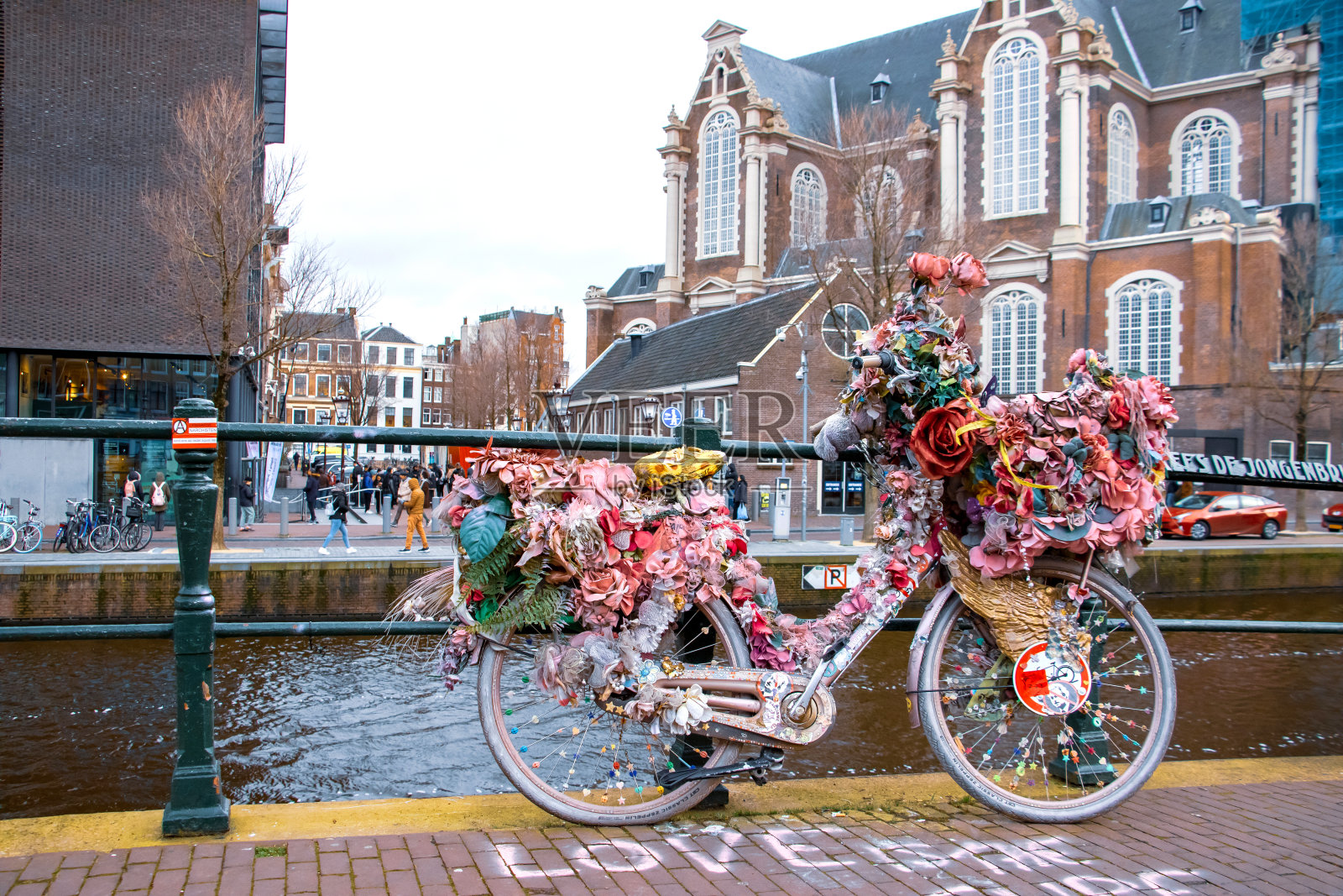 冬天，阿姆斯特丹王子运河上的粉色自行车上装满了鲜花照片摄影图片