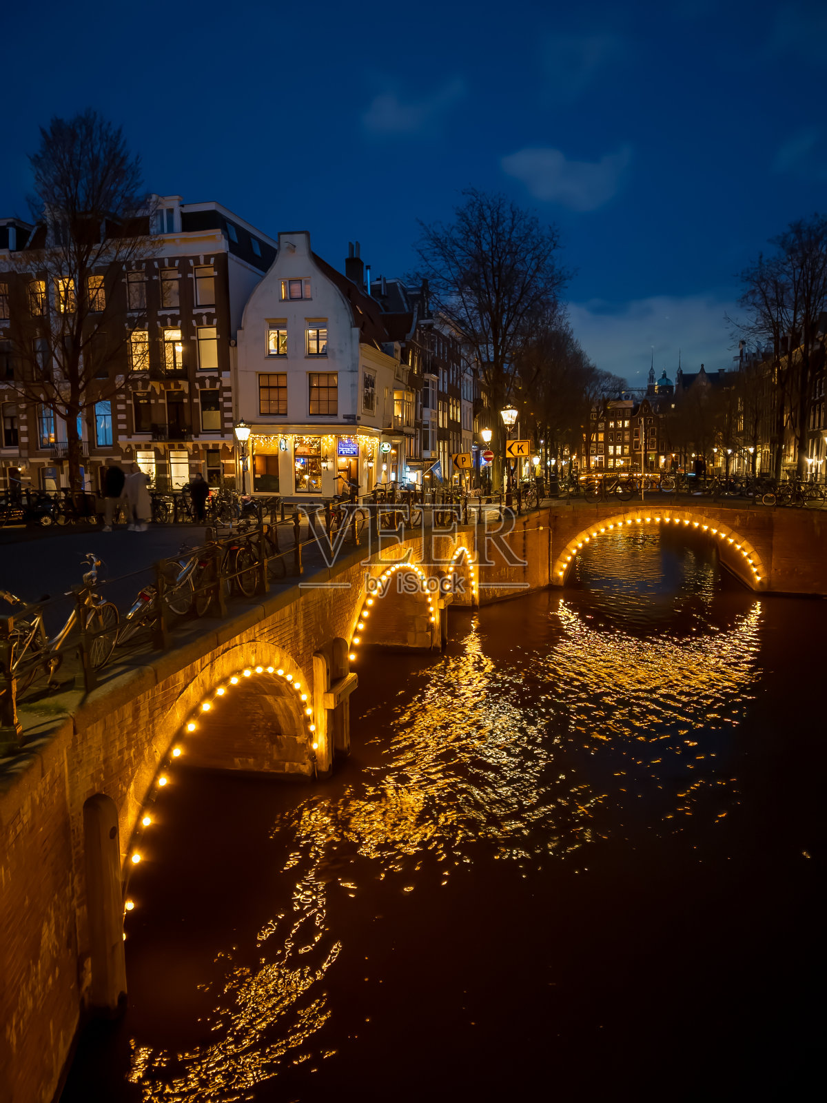 冬天，阿姆斯特丹凯泽运河上的桥梁在夜晚灯火通明照片摄影图片