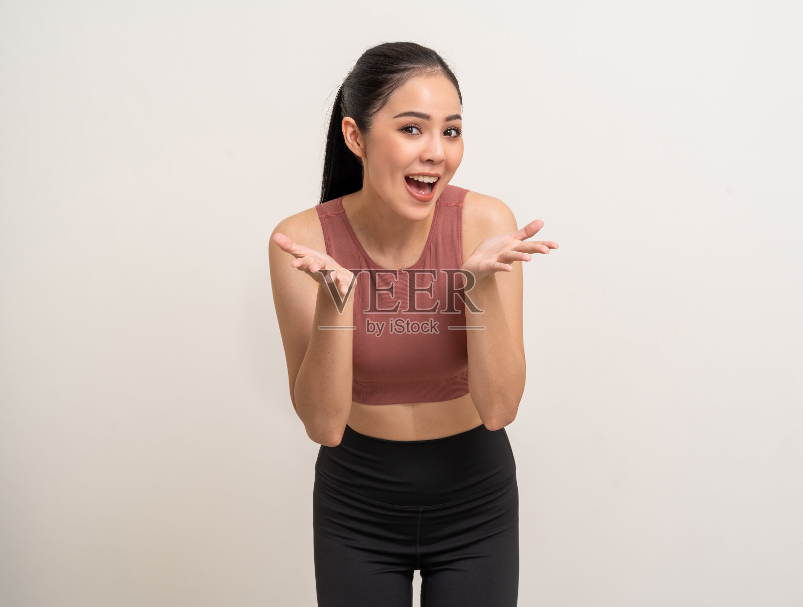 年轻美丽的亚洲妇女与运动服大声喊出哇，手在嘴上宣布孤立。快乐健康苗条的身材和坚定的拉丁迷人的运动女性姿势锻炼锻炼照片摄影图片