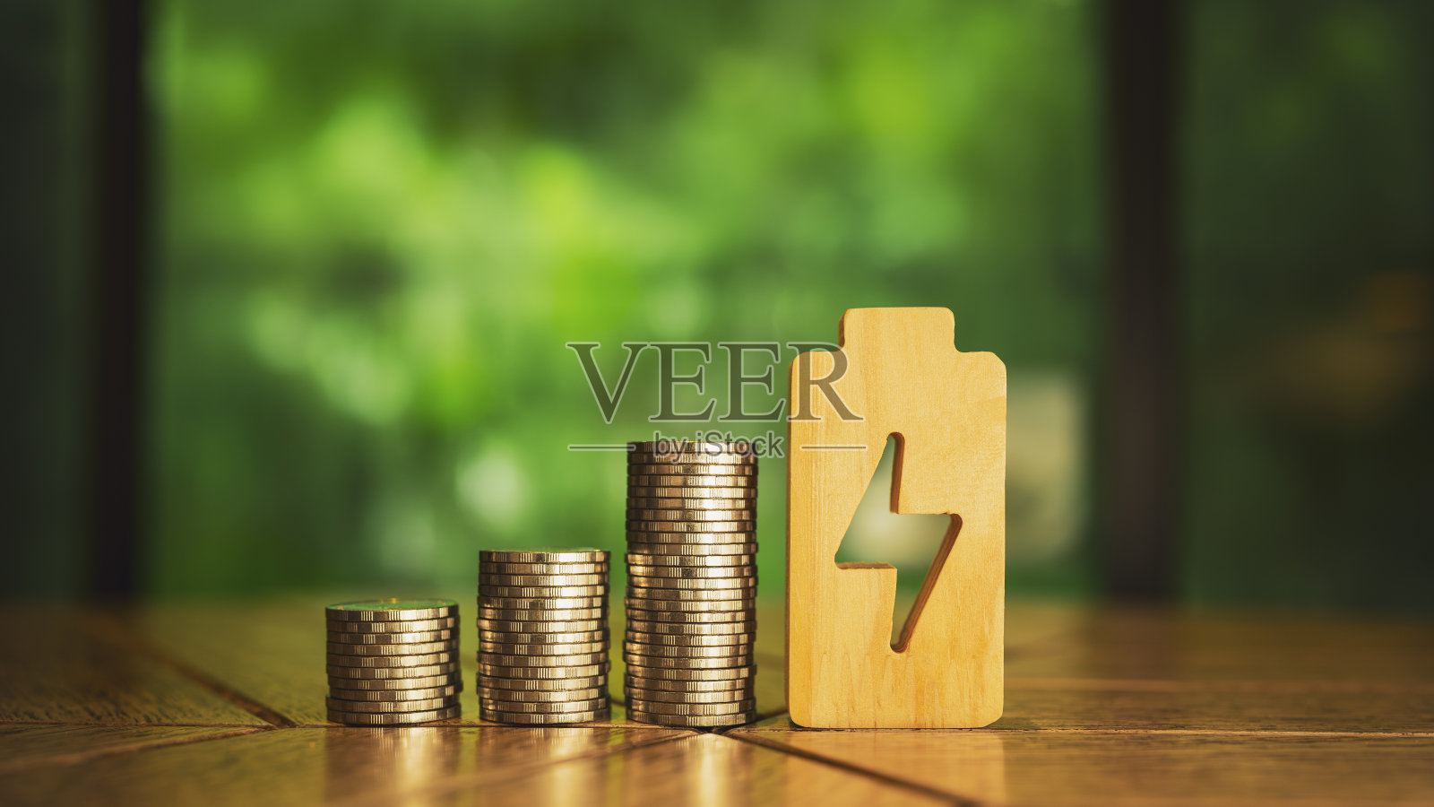 一堆硬币和一个电力符号，这是一个电力生产成本更高的概念，导致必须支付电费的人的费用也增加。照片摄影图片