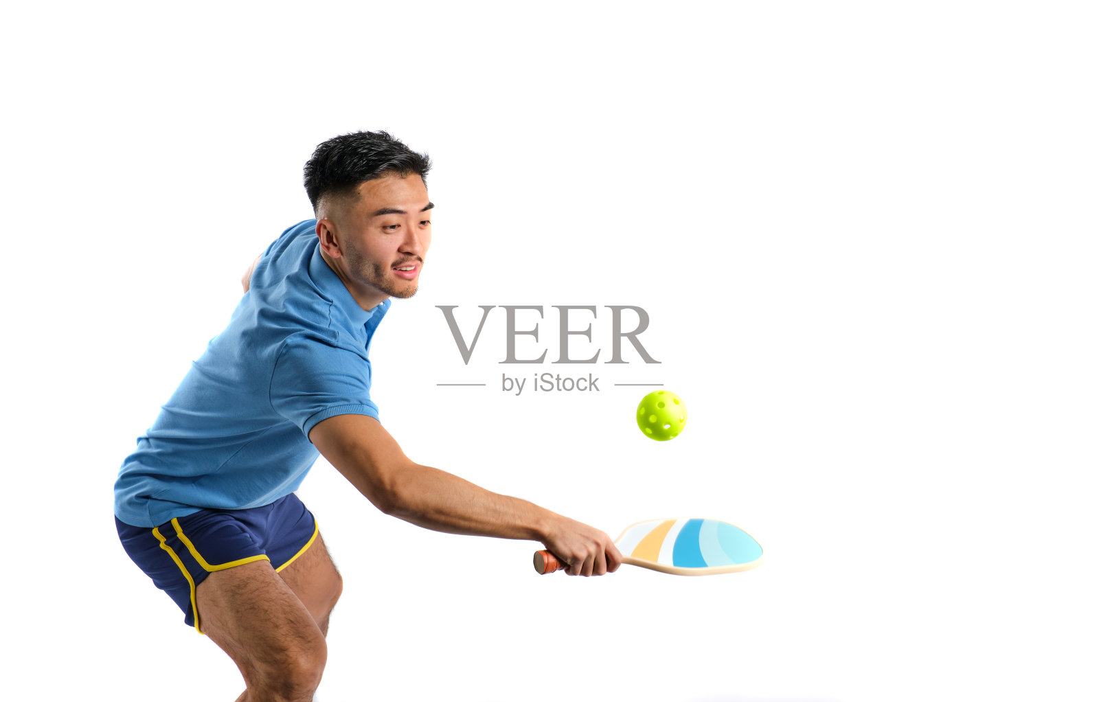 穿着蓝色运动服的东方男孩在白色背景上打匹克球照片摄影图片