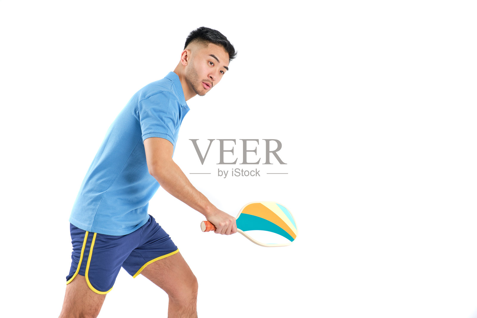 亚洲男孩与匹克球桨的位置击球在白色背景照片摄影图片