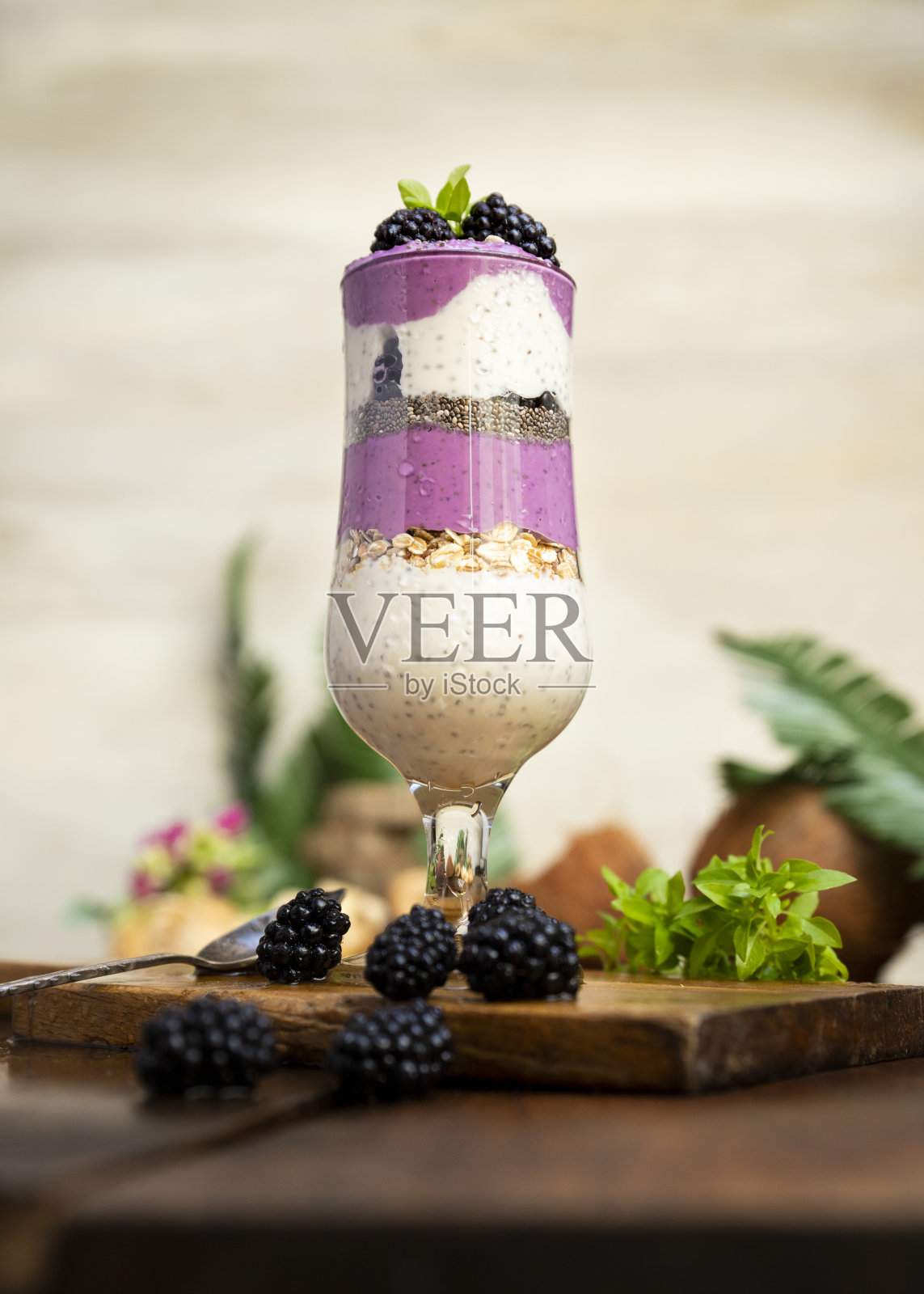 黑莓冰沙与奇亚籽在玻璃与新鲜浆果和薄荷在木桌照片摄影图片