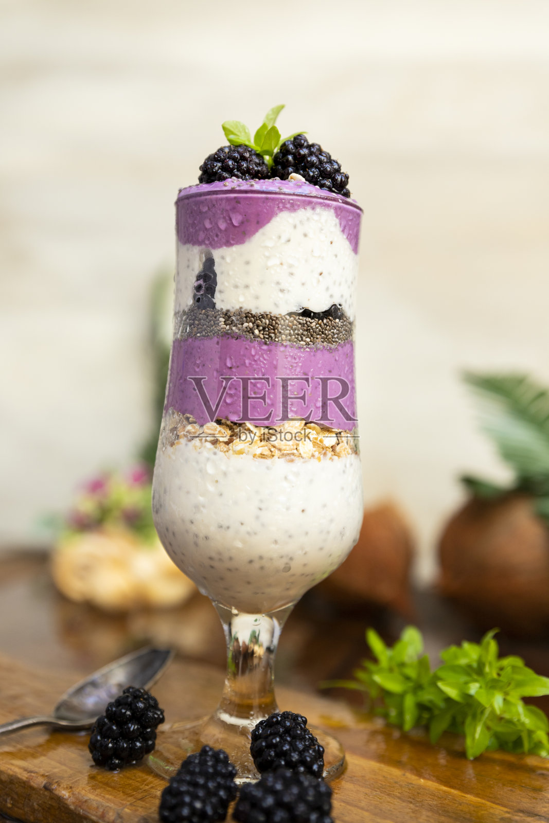 黑莓冰沙与奇亚籽在玻璃与新鲜浆果和薄荷在木桌照片摄影图片