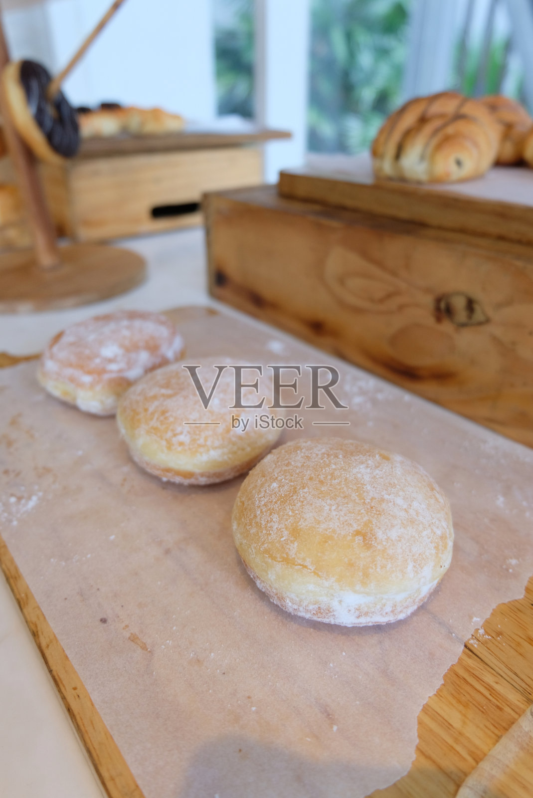 木桌上放着炸肉肠、煎蛋饼或甜甜圈。照片摄影图片