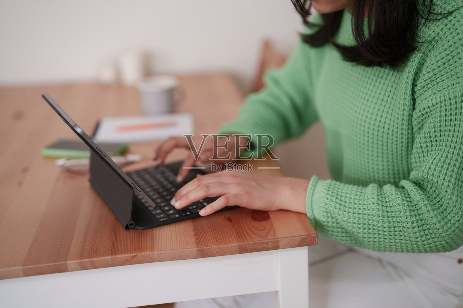 接近千禧年亚洲女性使用数字平板电脑，在家庭办公室工作照片摄影图片