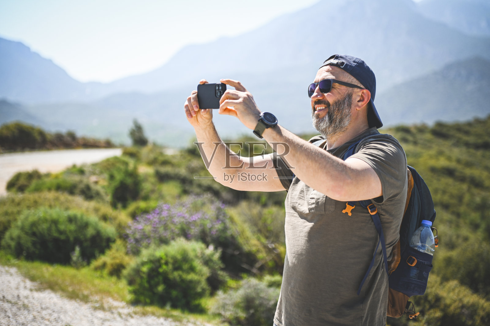 成熟的成年男子旅行者带手机照片摄影图片