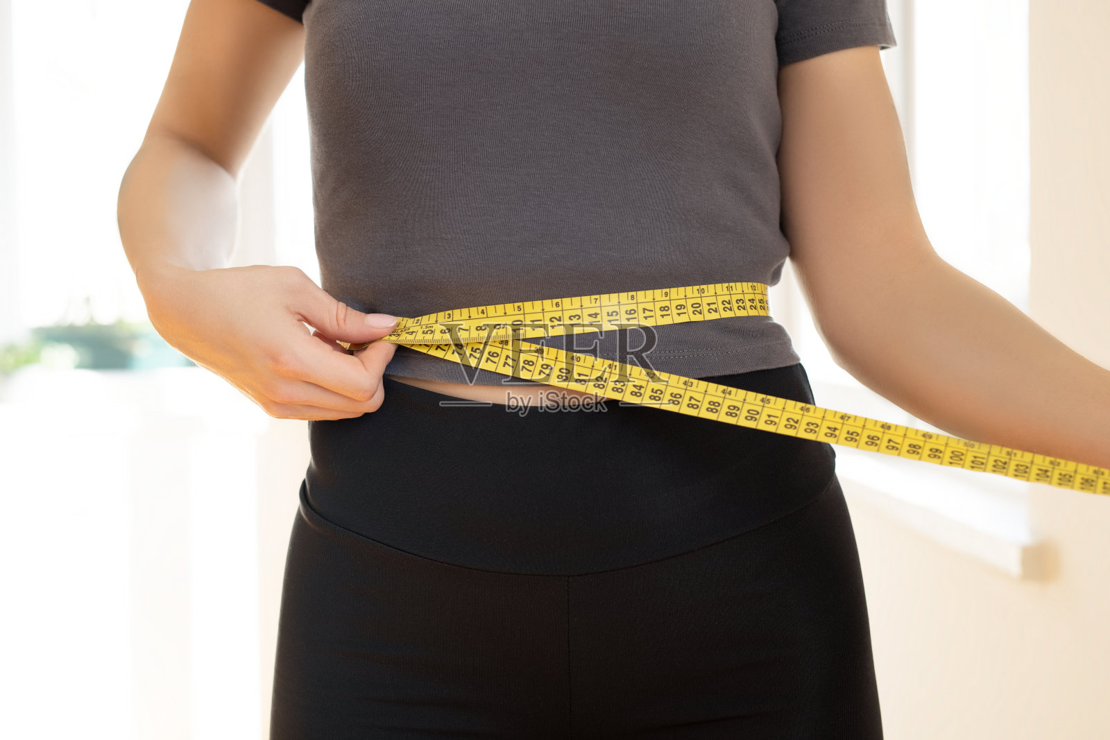 妇女用卷尺量腰围照片摄影图片