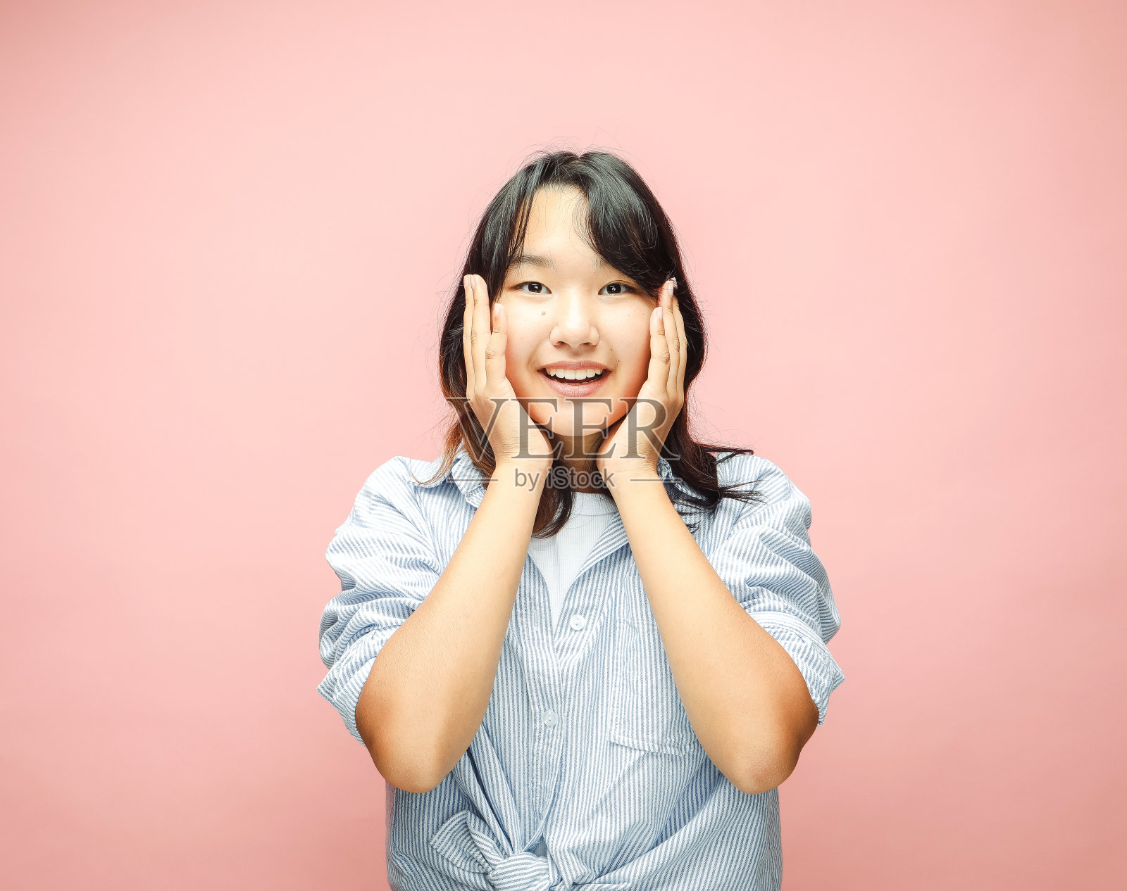 开朗的年轻亚洲妇女惊讶与震惊交易，孤立在粉红色的背景照片摄影图片