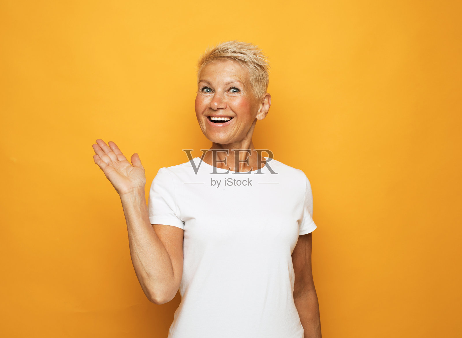 黄色背景上的高级女性肖像，带着可爱的微笑照片摄影图片