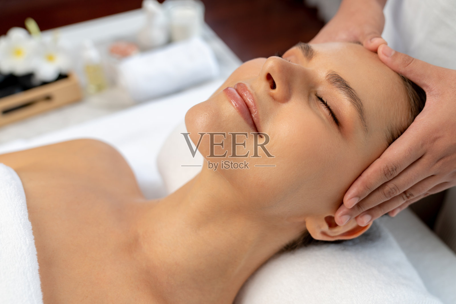 享受放松抗压力头部按摩的高加索女性。静照片摄影图片