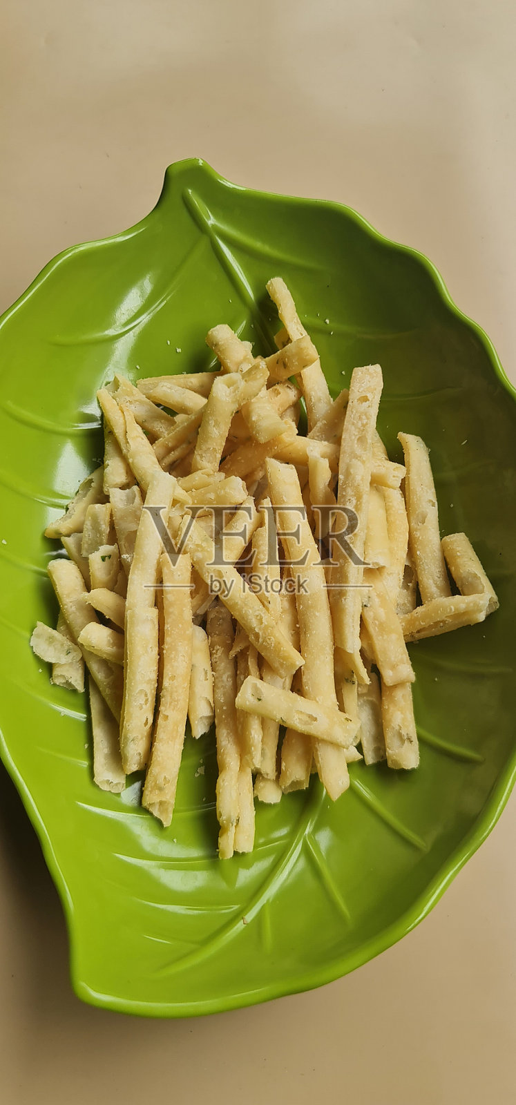 奶酪棒蛋糕放在叶子形状的绿色盘子上，这种蛋糕通常在开斋节之前制作和出售，用于开斋节，或者作为礼物包裹赠送。照片摄影图片