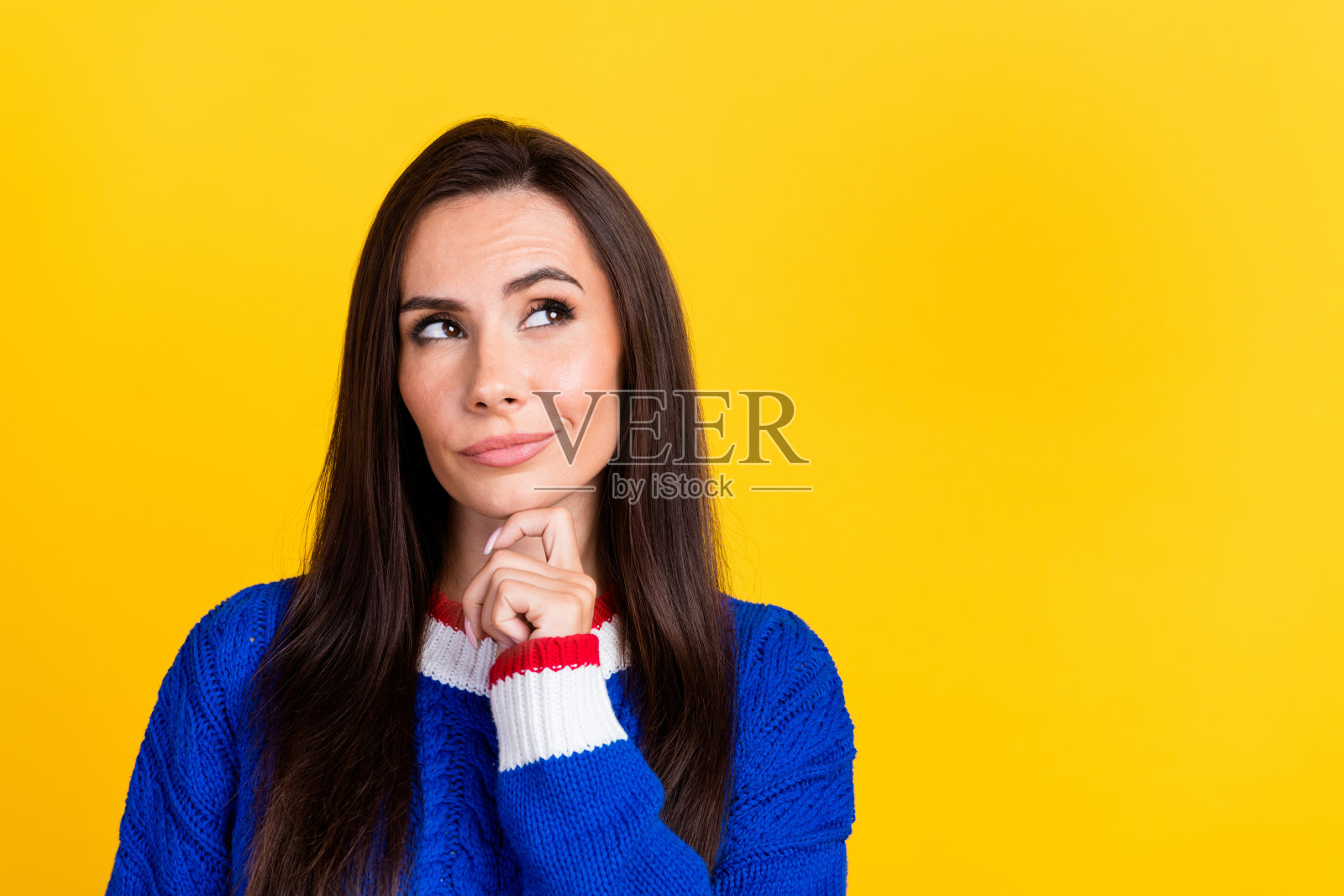 照片聪明的黑发女士穿着蓝色针织毛衣触摸下巴和头脑风暴沉思孤立的黄色背景照片摄影图片