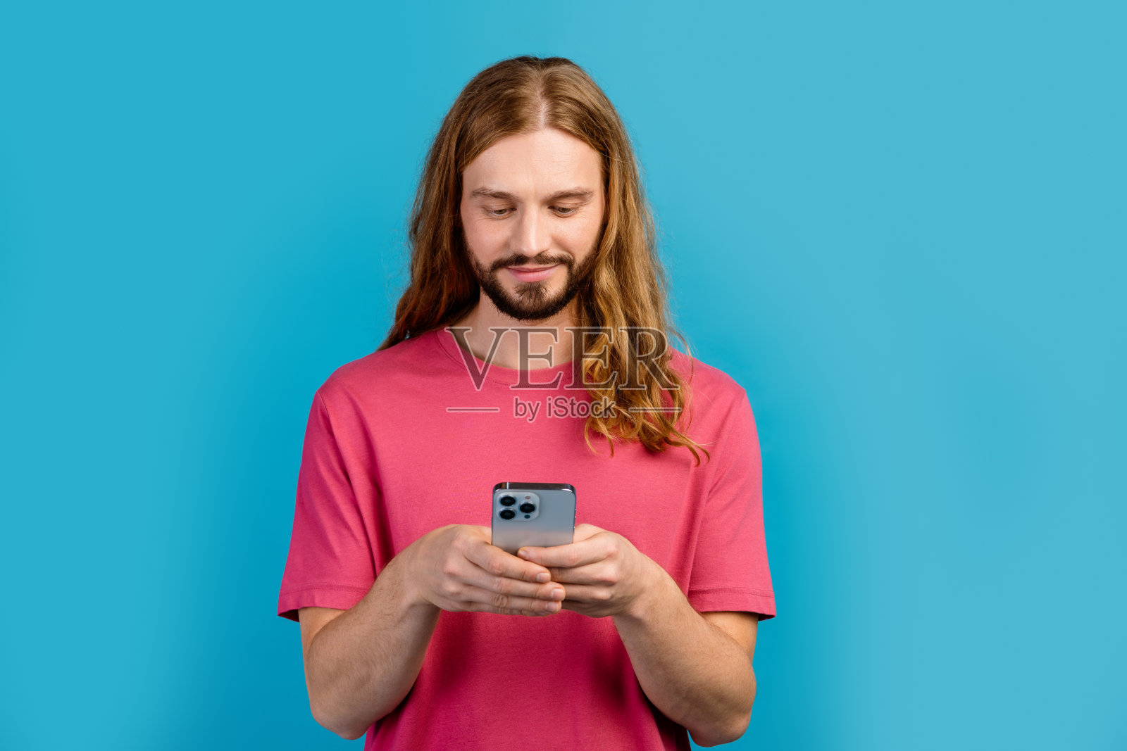 有吸引力的积极男子手持智能手机聊天的照片，空白空间广告孤立在蓝色背景上照片摄影图片