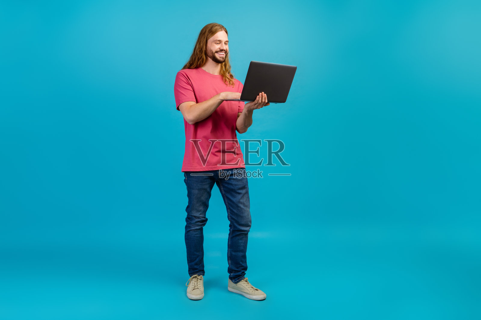 开朗的人的全尺寸肖像用笔记本电脑在蓝色背景上交流孤立的空间照片摄影图片