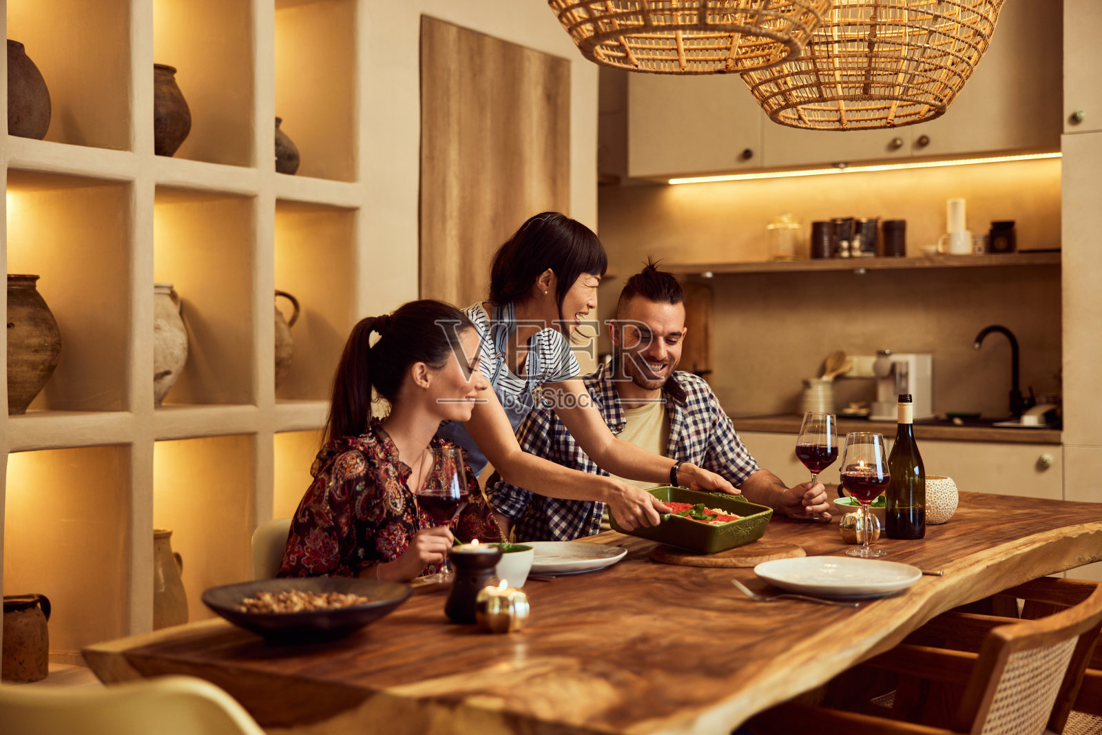 一群可爱的朋友在一起吃晚餐，由他们的亚洲朋友招待。照片摄影图片