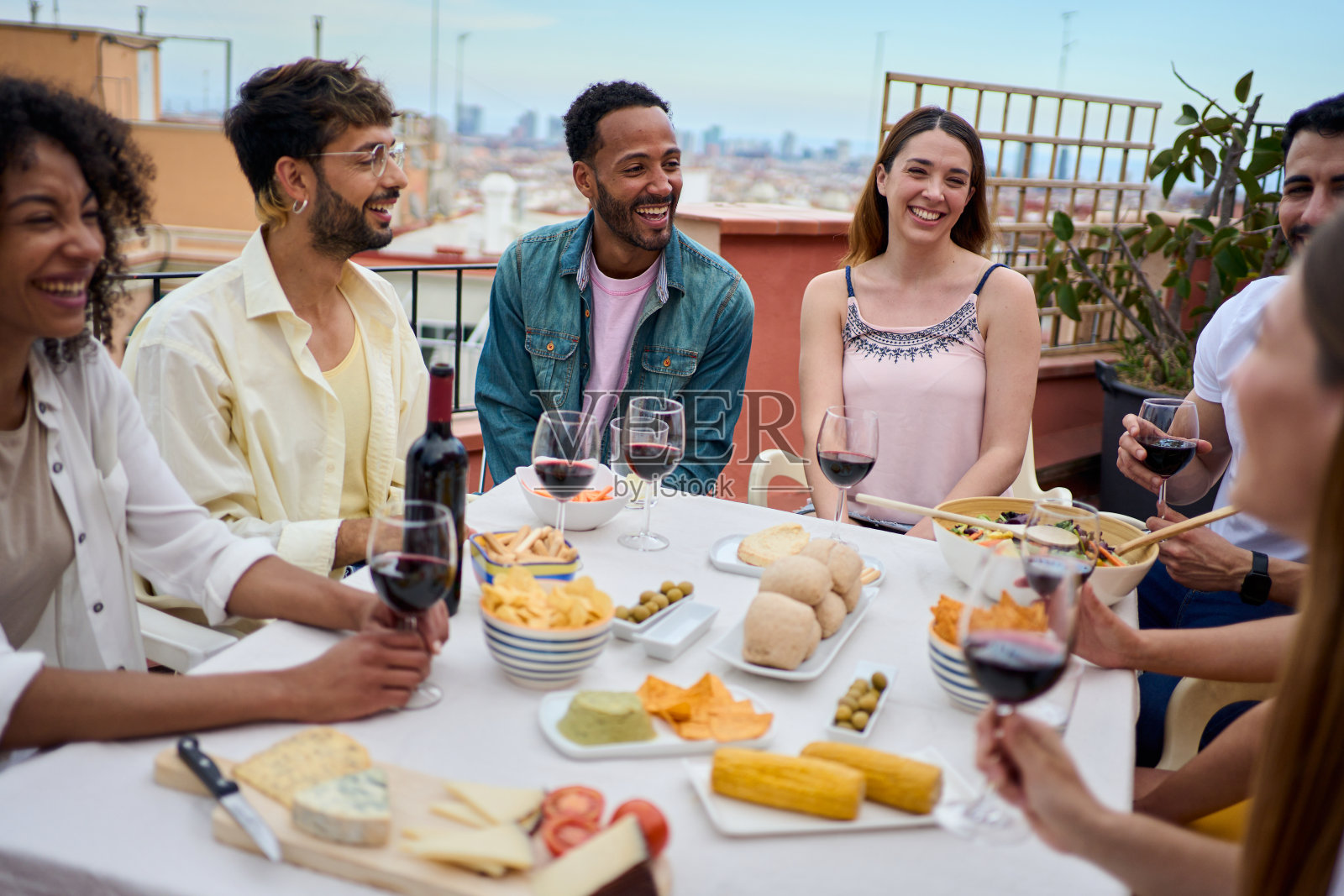 快乐的一群多种族的年轻成年朋友一起在户外享用午餐，庆祝小吃派对照片摄影图片