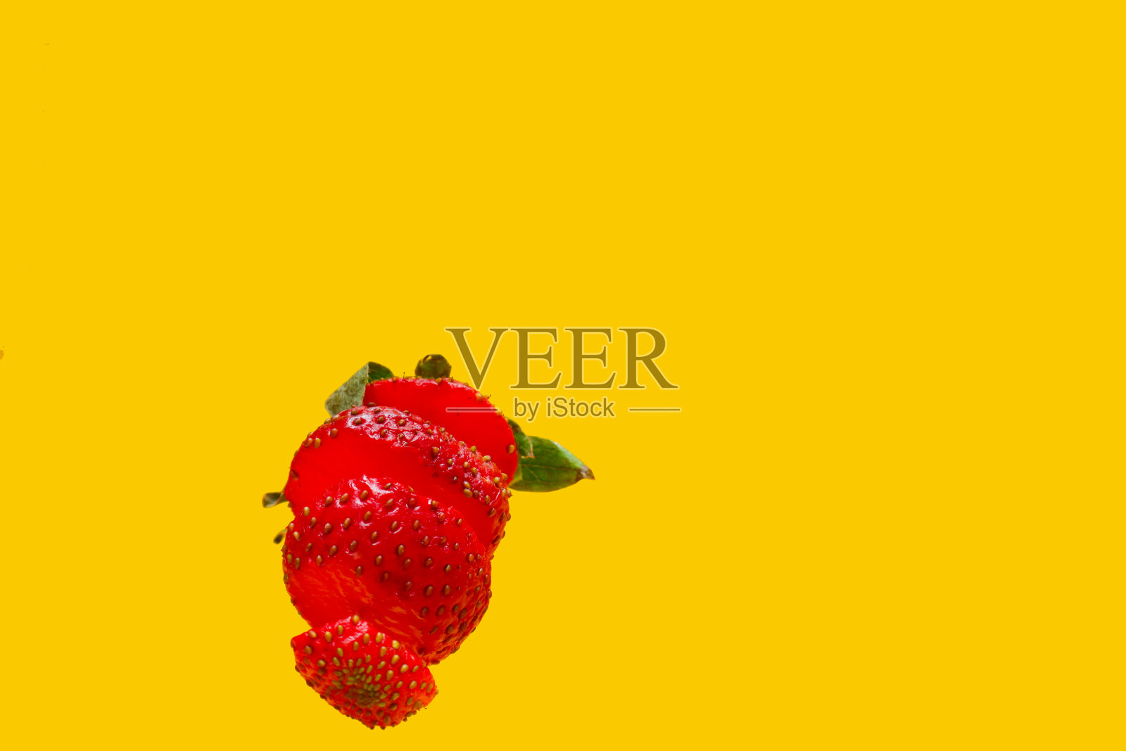 照片中的草莓被隔离在黄色的背景上照片摄影图片