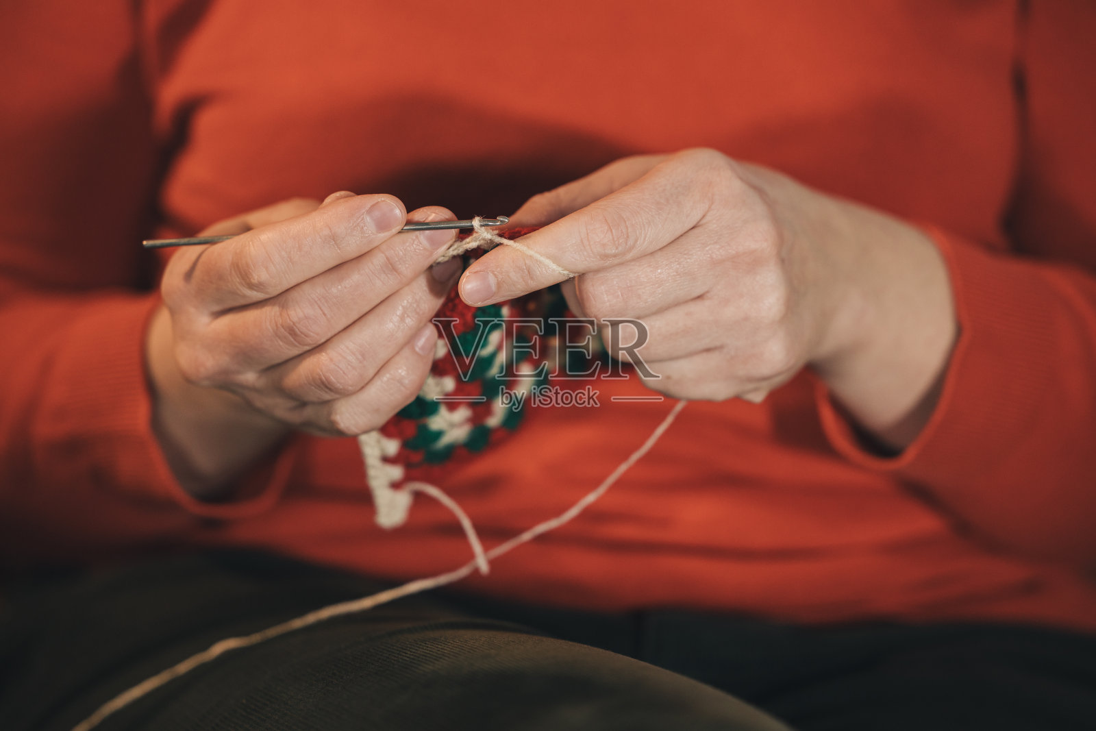 一个女人正坐在沙发上织毛衣照片摄影图片