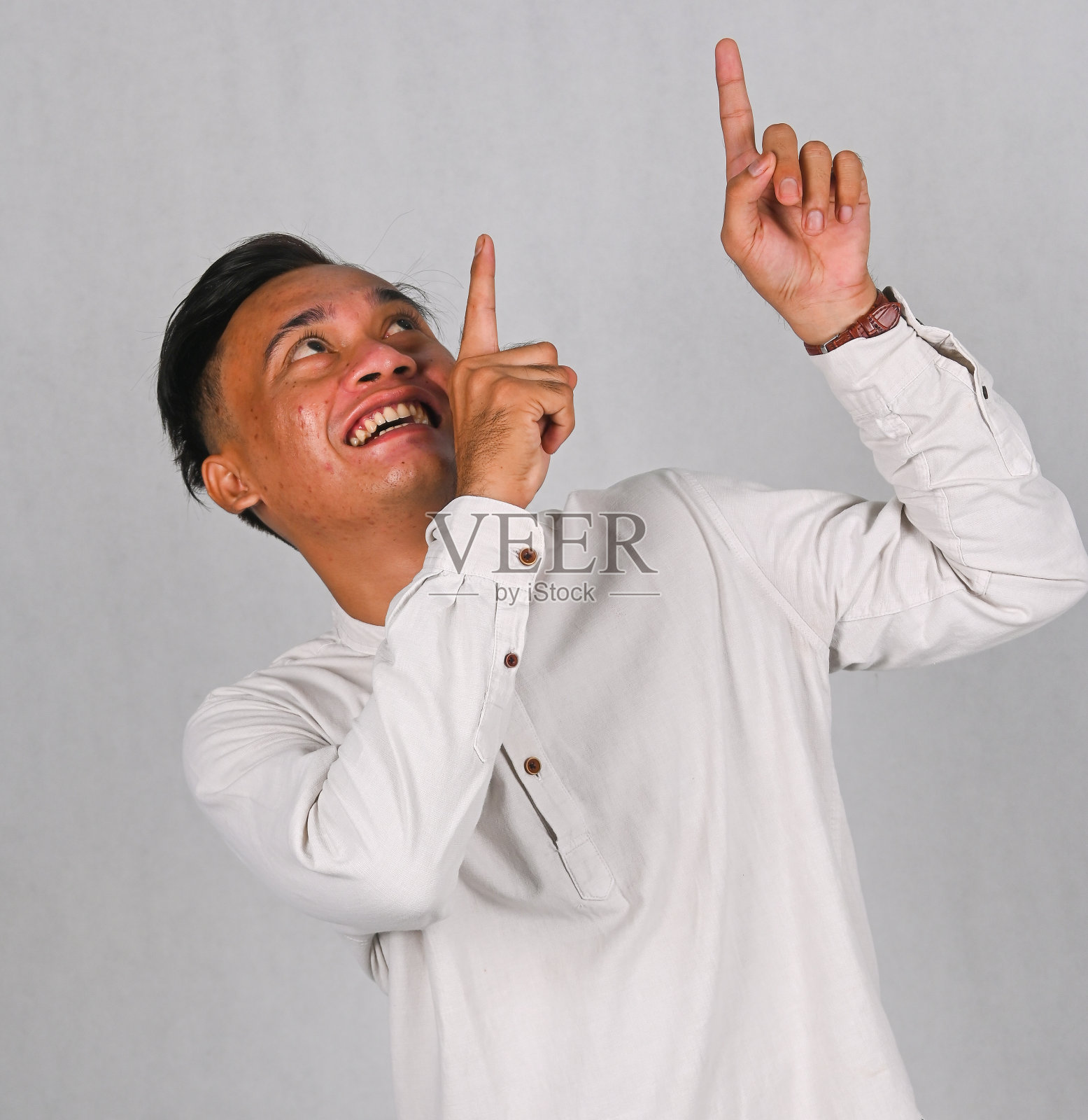 亚洲年轻人兴奋地指着上面照片摄影图片