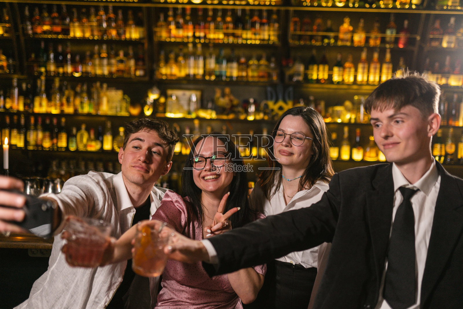 亲密的朋友们在假日派对结束后在酒吧拍照照片摄影图片