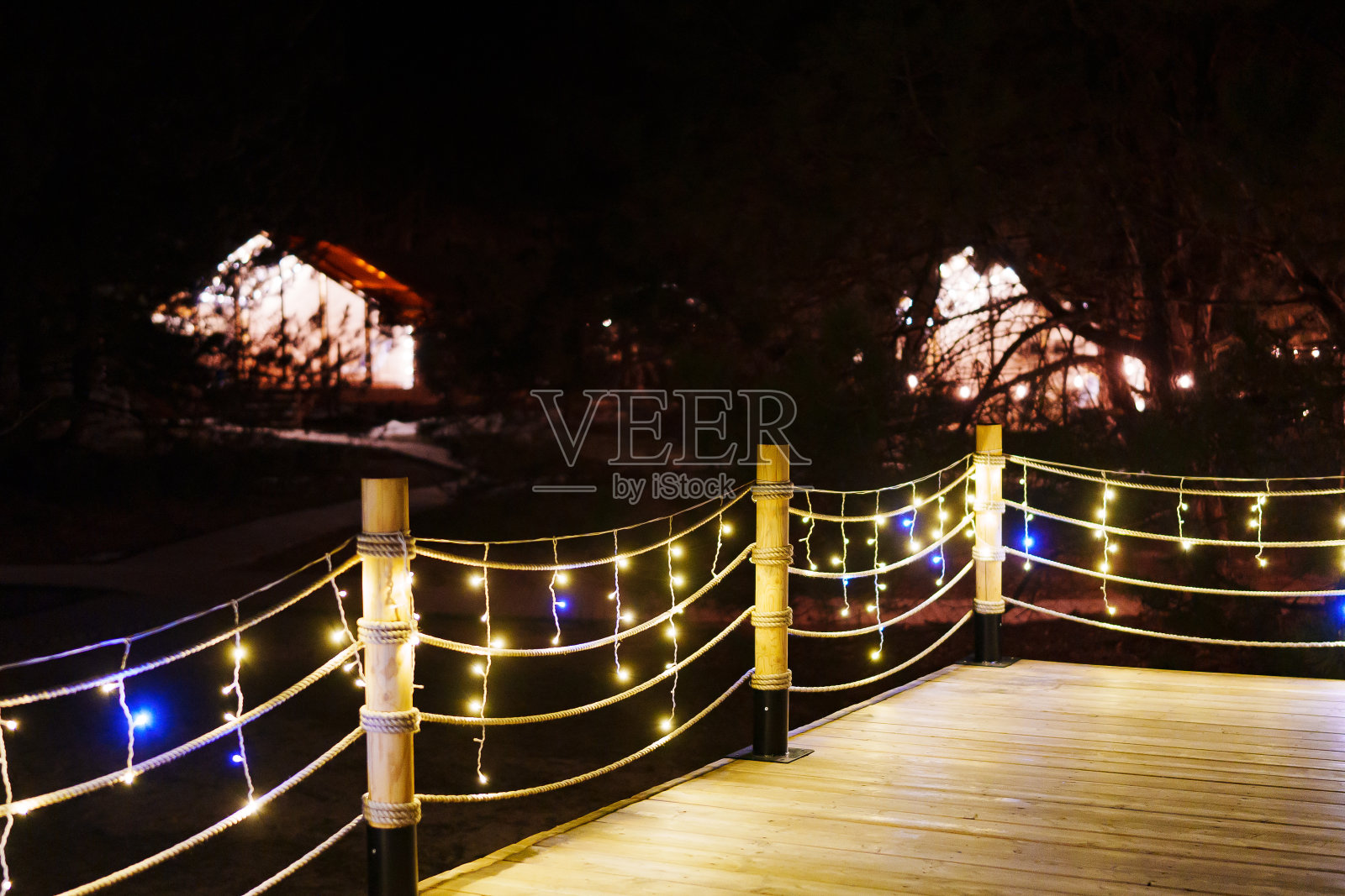 豪华野营的露台上有灯泡。林中休闲的小木屋。照片摄影图片