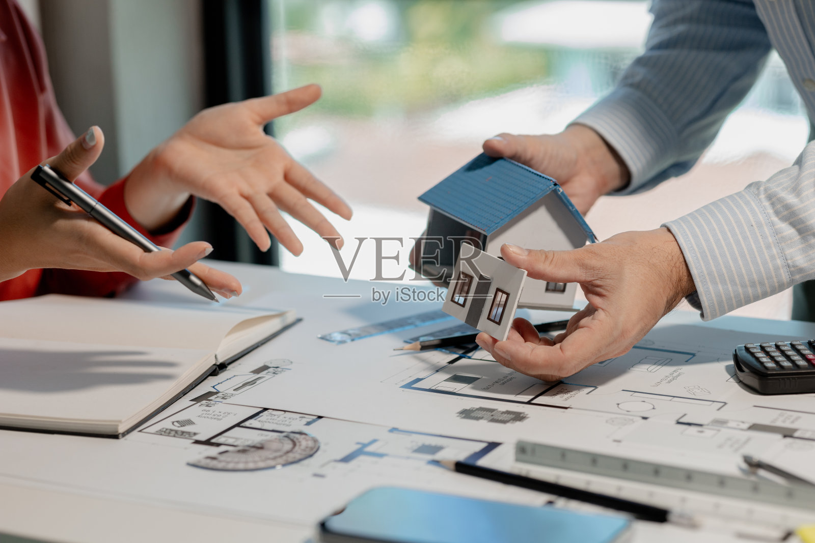 建筑师和工作人员使用指南针根据蓝图在不同位置测量该地区，以便在建造房屋之前准确计算宽度和长度。照片摄影图片