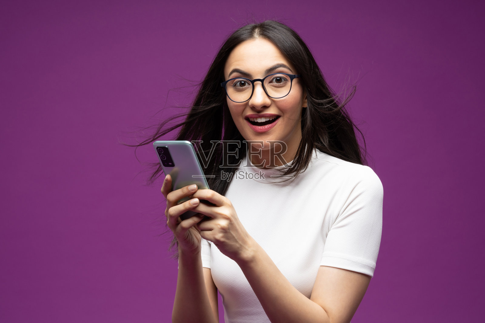 年轻女子使用手机孤立的紫色背景股票照片照片摄影图片