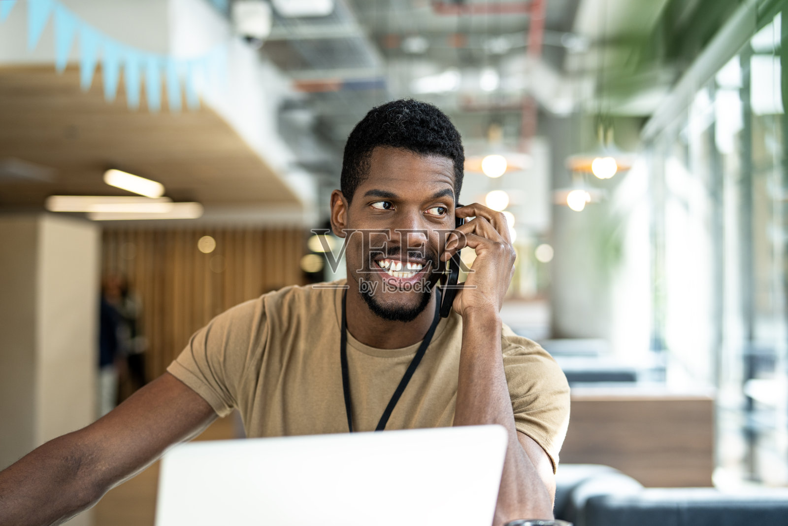 年轻的非裔美国商人在办公室里打电话照片摄影图片