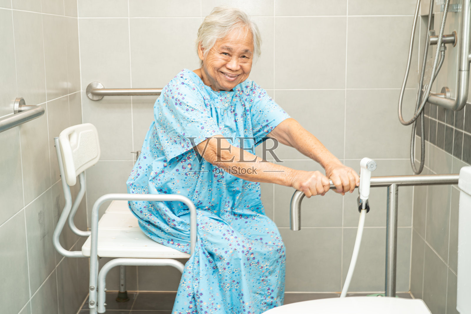 亚洲老年妇女患者在护理医院使用卫生间卫生间处理安全，健康强的医疗理念。照片摄影图片