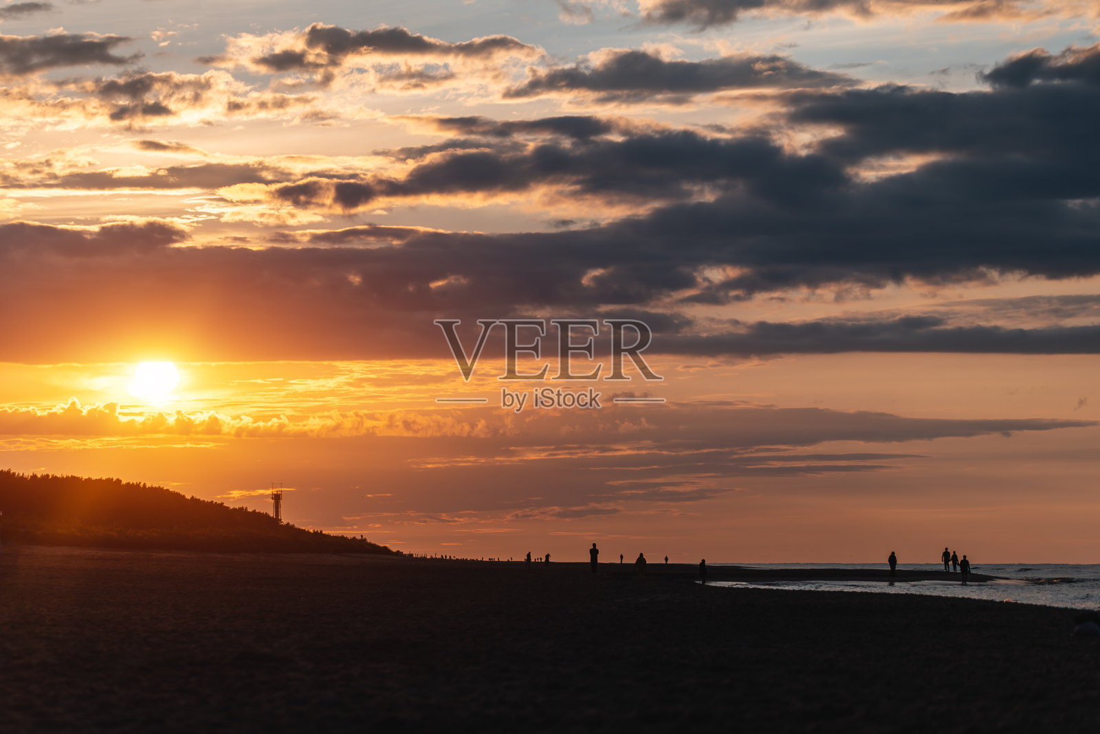 美丽的日落在海上和海滩，戏剧性的云和橙色的阳光照片摄影图片